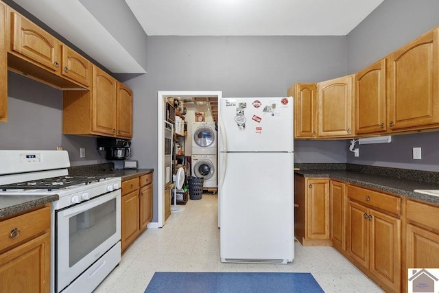 kitchen featuring light floors, white appliances, dark countertops, and stacked washer / drying machine