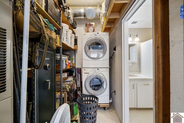 clothes washing area featuring stacked washer / drying machine and laundry area