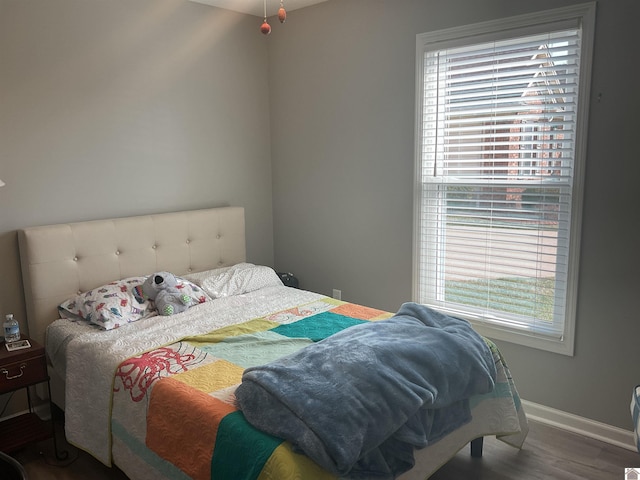 bedroom featuring wood finished floors and baseboards