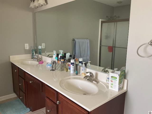 bathroom with double vanity, a stall shower, and a sink