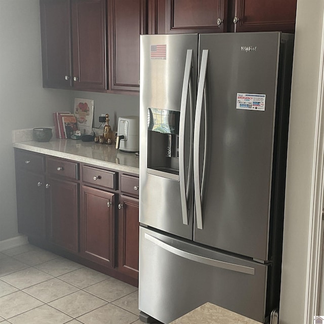 kitchen featuring light countertops, dark brown cabinetry, stainless steel refrigerator with ice dispenser, and light tile patterned floors