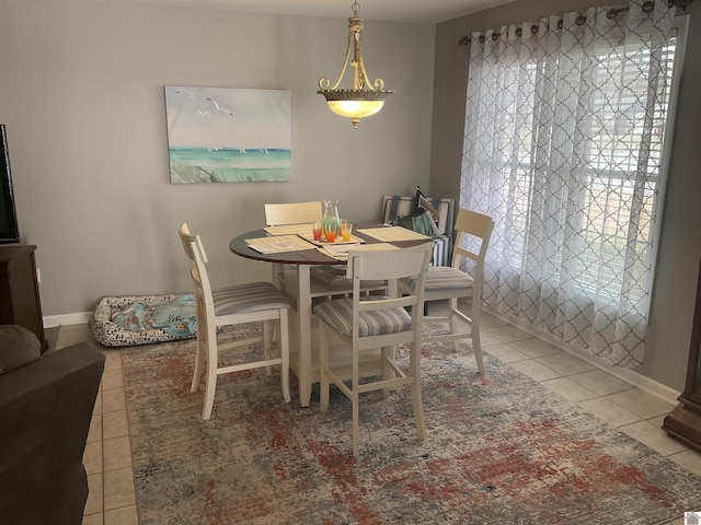 dining area featuring light tile patterned floors and baseboards