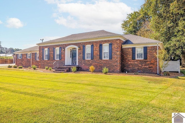 view of front of house featuring brick siding, a front yard, and a shingled roof