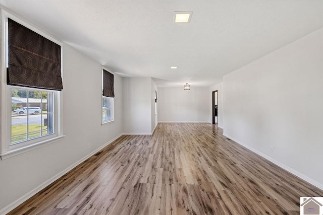 unfurnished living room with baseboards and light wood finished floors