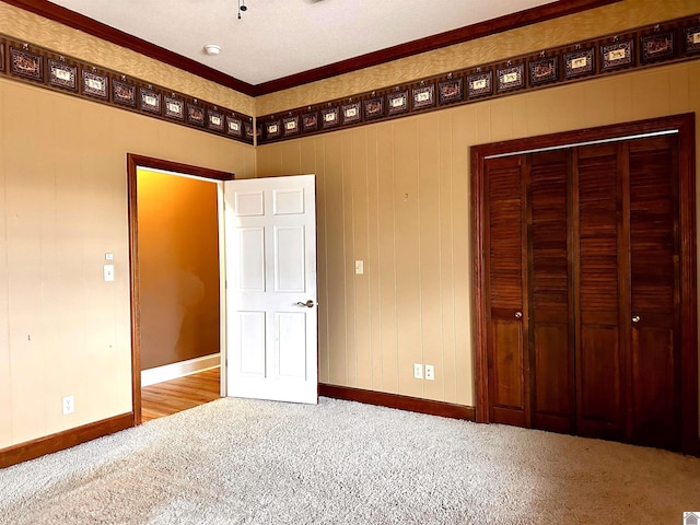 unfurnished bedroom with a closet, carpet, and baseboards