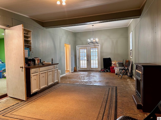 interior space featuring a chandelier, crown molding, and french doors