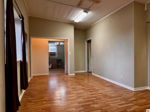 unfurnished room with baseboards, ornamental molding, wood ceiling, and light wood-style floors