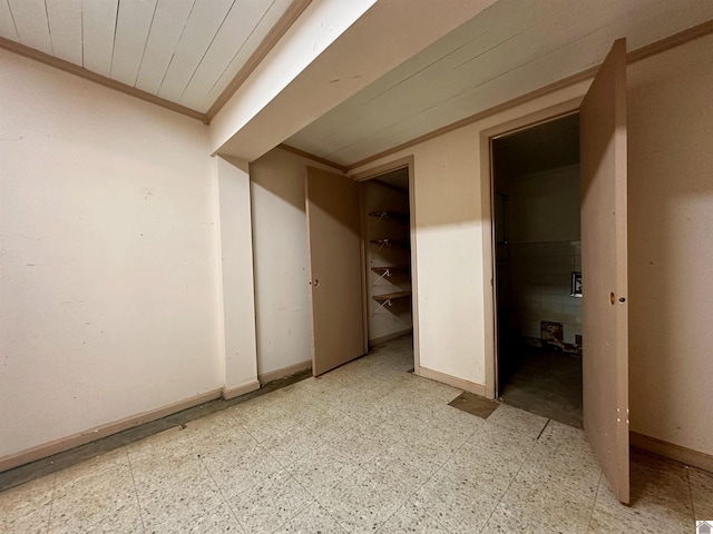 interior space featuring light floors, ornamental molding, and baseboards