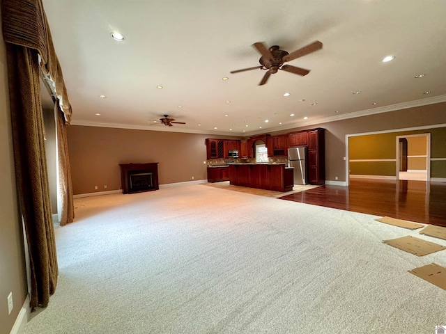 unfurnished living room featuring ornamental molding, recessed lighting, and baseboards