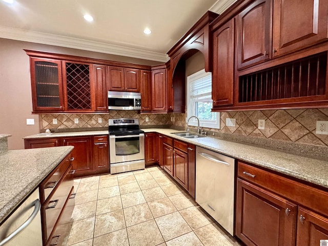 kitchen with crown molding, light tile patterned floors, backsplash, appliances with stainless steel finishes, and a sink