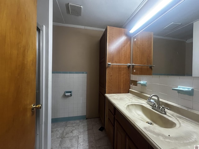 bathroom featuring tile walls, visible vents, crown molding, and vanity