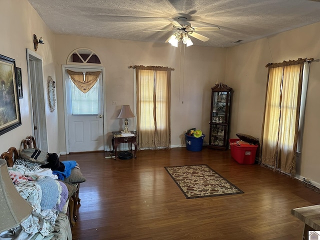 entrance foyer with a textured ceiling, wood finished floors, a ceiling fan, and baseboards