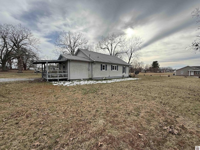 rear view of house with a yard and metal roof