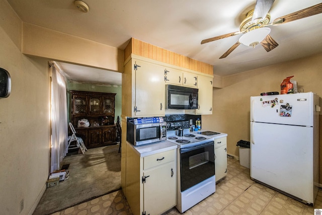 kitchen featuring stainless steel microwave, freestanding refrigerator, light countertops, black microwave, and range with electric stovetop