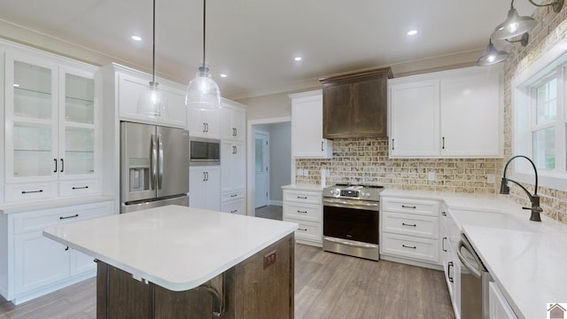 kitchen featuring stainless steel appliances, a sink, light countertops, tasteful backsplash, and custom range hood