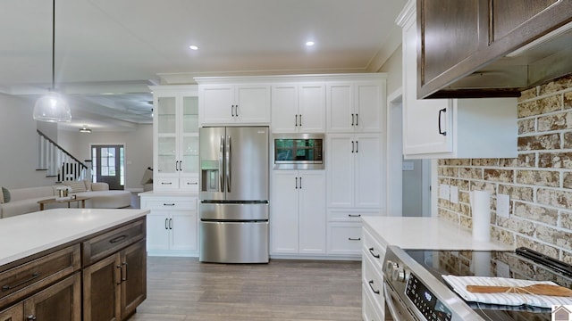 kitchen featuring appliances with stainless steel finishes, light countertops, white cabinets, and light wood-style flooring