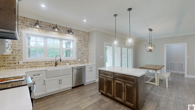 kitchen featuring visible vents, decorative backsplash, a sink, wood finished floors, and dishwasher