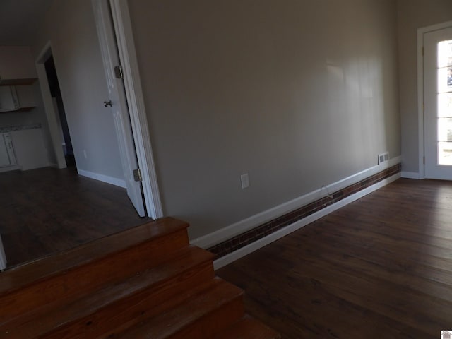 stairs with visible vents, baseboards, and wood finished floors