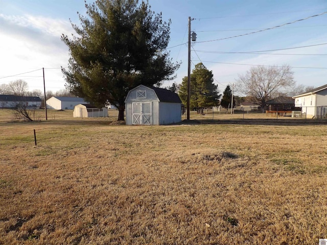 view of yard featuring a storage unit, an outdoor structure, and fence