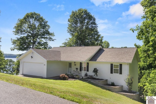 ranch-style home with a garage, a front lawn, and a shingled roof