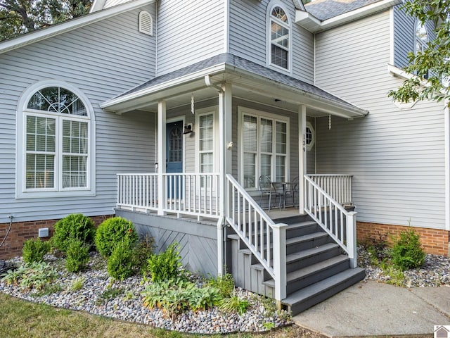 doorway to property with crawl space, a porch, and roof with shingles