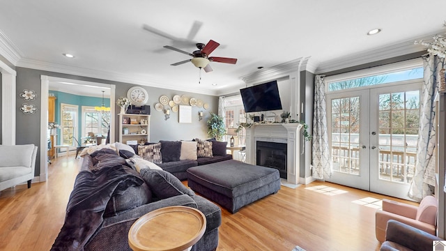 living room featuring plenty of natural light, crown molding, wood finished floors, and french doors