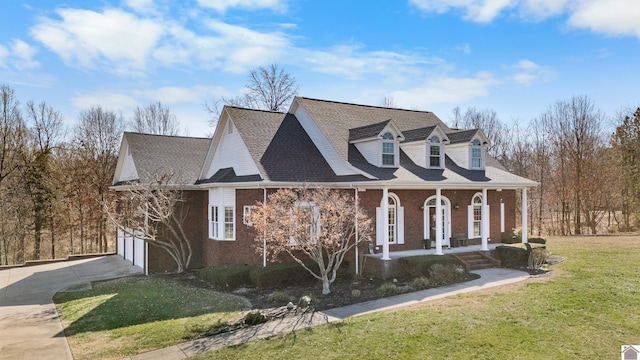 view of front of home featuring covered porch, a garage, brick siding, concrete driveway, and a front yard