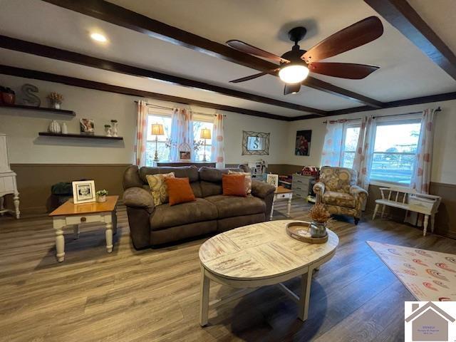 living room with a healthy amount of sunlight, light wood-style flooring, and beam ceiling