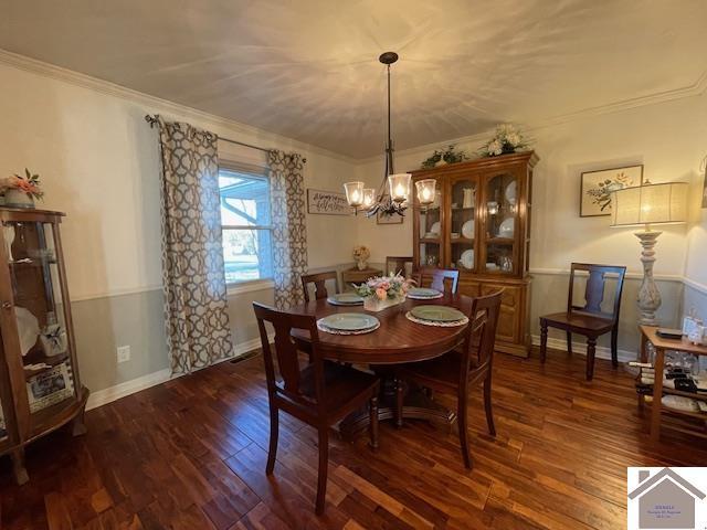 dining space with an inviting chandelier, baseboards, ornamental molding, and dark wood finished floors