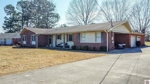 single story home featuring a front lawn, brick siding, driveway, and an attached garage