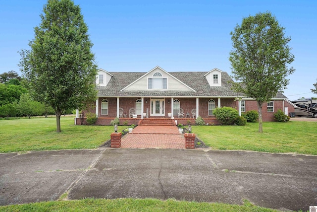 view of front facade featuring a front lawn, a porch, and brick siding