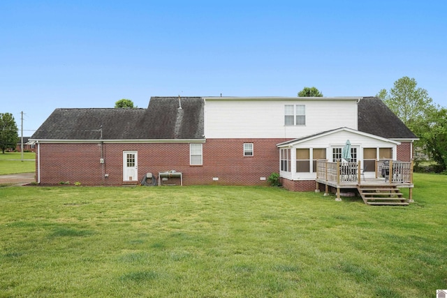 back of house with a sunroom, brick siding, a lawn, and a wooden deck