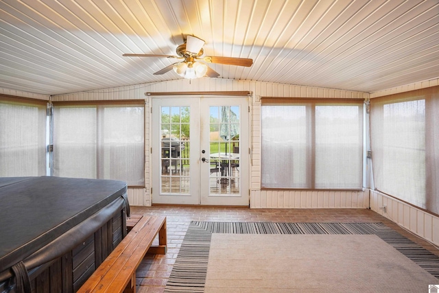 unfurnished sunroom with a ceiling fan, french doors, and vaulted ceiling