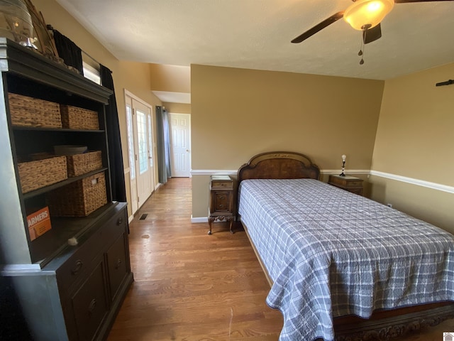 bedroom featuring ceiling fan, baseboards, and wood finished floors