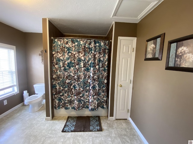 bathroom featuring toilet, a textured ceiling, baseboards, and shower / bath combination with curtain