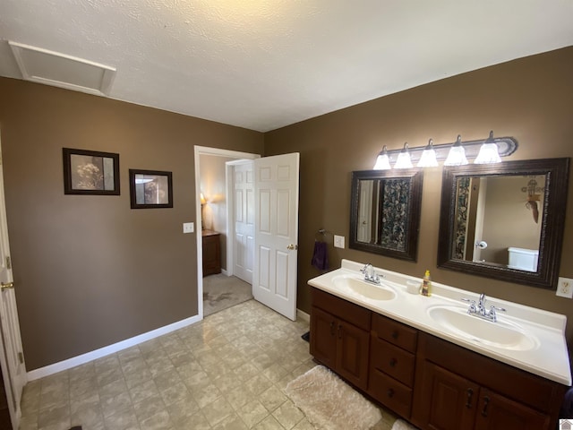 full bath with double vanity, tile patterned floors, a sink, and baseboards