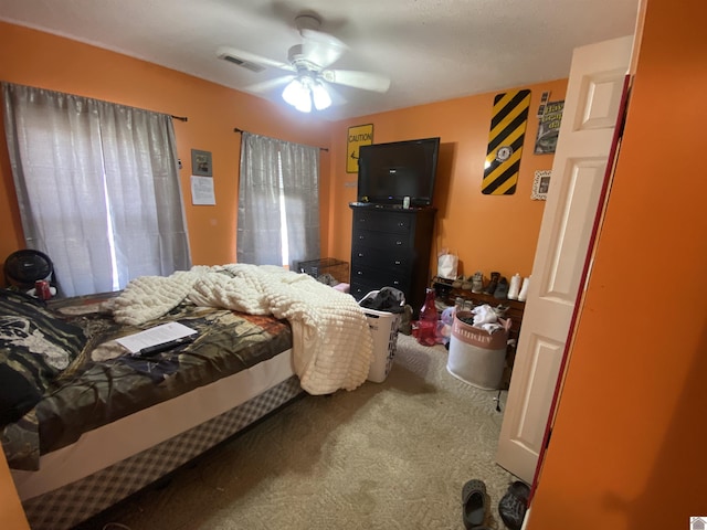 bedroom with carpet floors, visible vents, and a ceiling fan