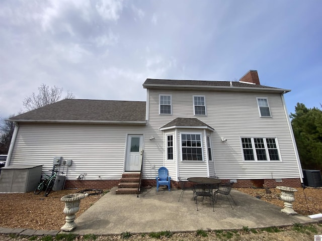 back of property featuring entry steps, central AC, crawl space, a chimney, and a patio area