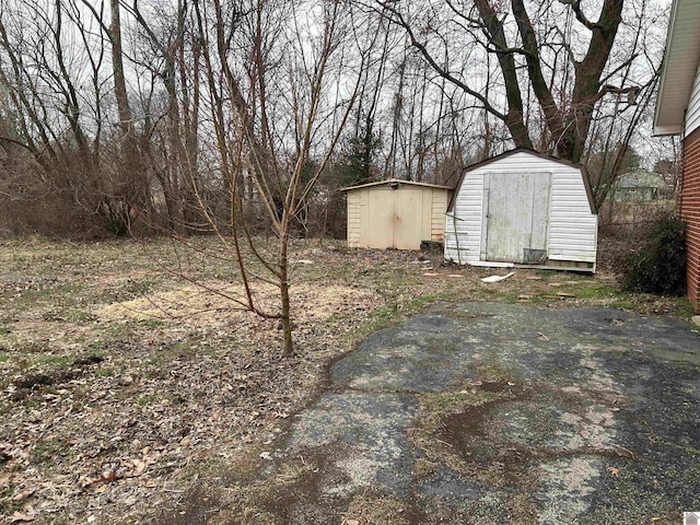 view of yard featuring a storage shed and an outbuilding