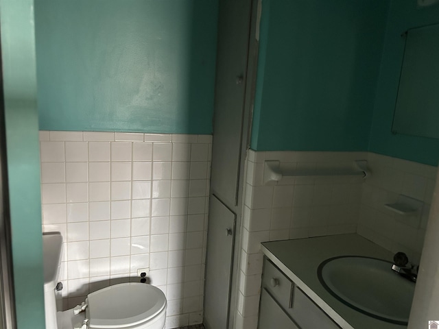 bathroom featuring tile walls, vanity, and toilet