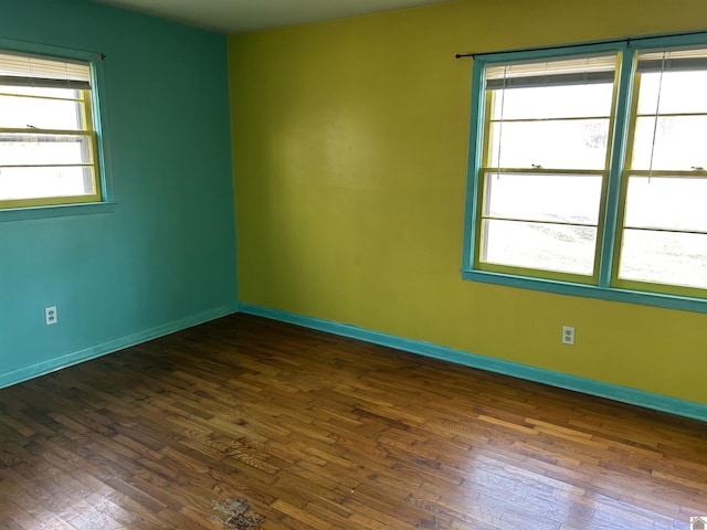 spare room with dark wood finished floors and baseboards