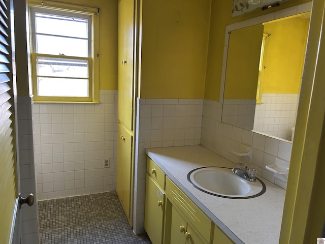 bathroom featuring a wainscoted wall, tile patterned flooring, tile walls, and vanity