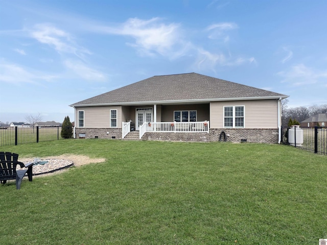 rear view of property featuring a lawn, a fenced backyard, crawl space, covered porch, and brick siding