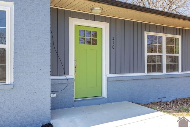 view of exterior entry featuring brick siding