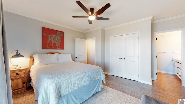 bedroom featuring a closet, baseboards, crown molding, and light wood finished floors