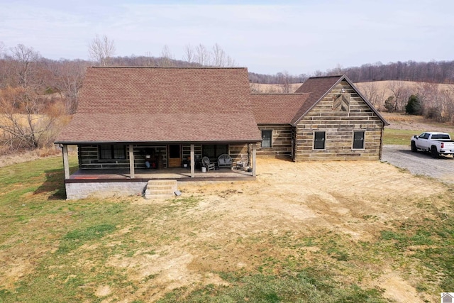 view of front of house featuring an outbuilding, roof with shingles, and an exterior structure