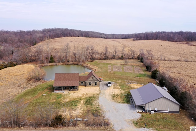 drone / aerial view with a water view, a wooded view, and a rural view