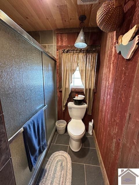 full bath featuring a stall shower, baseboards, toilet, wooden ceiling, and tile patterned flooring