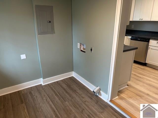 washroom with laundry area, electric panel, baseboards, light wood-style flooring, and washer hookup