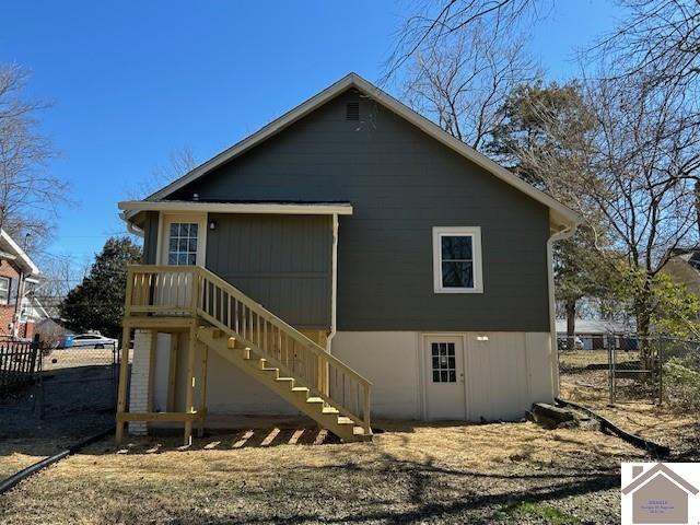 back of property featuring stairway and fence